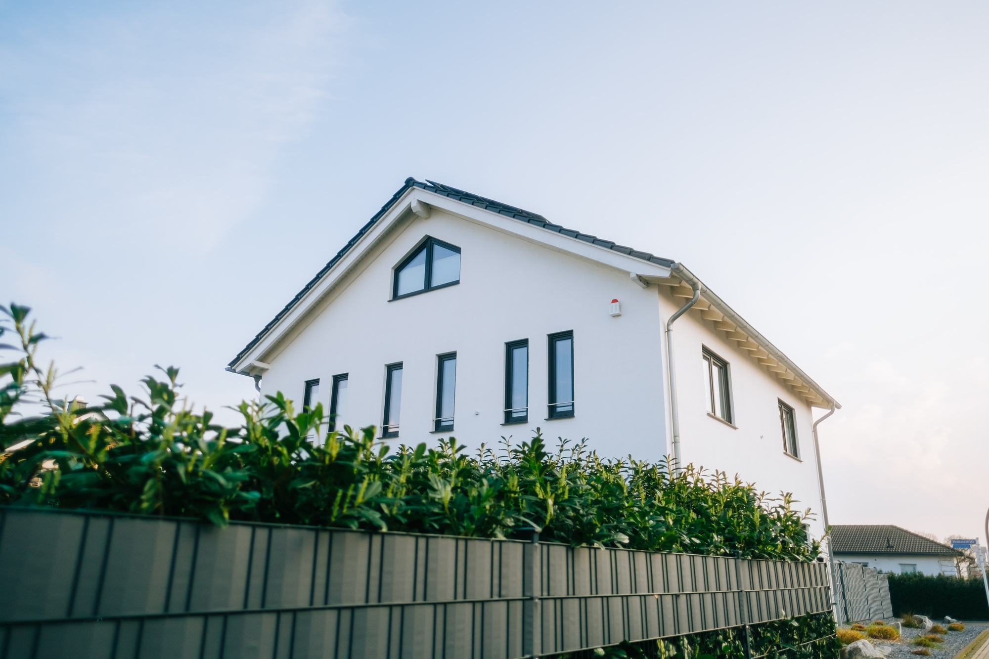 Modern white house in countryside Germany against blue sky
